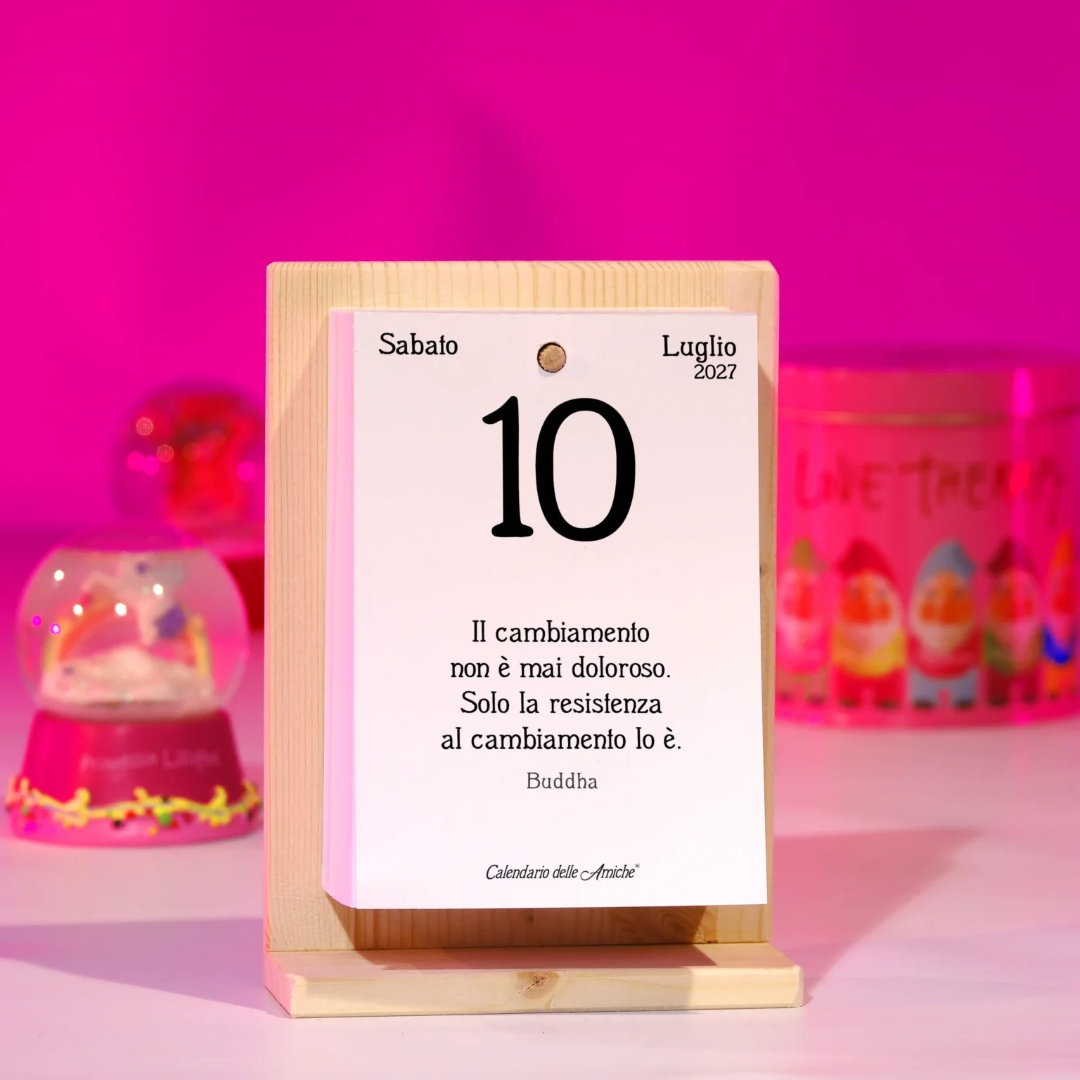 Calendario con sfondo rosa e souvenir con palla di vetro e neve